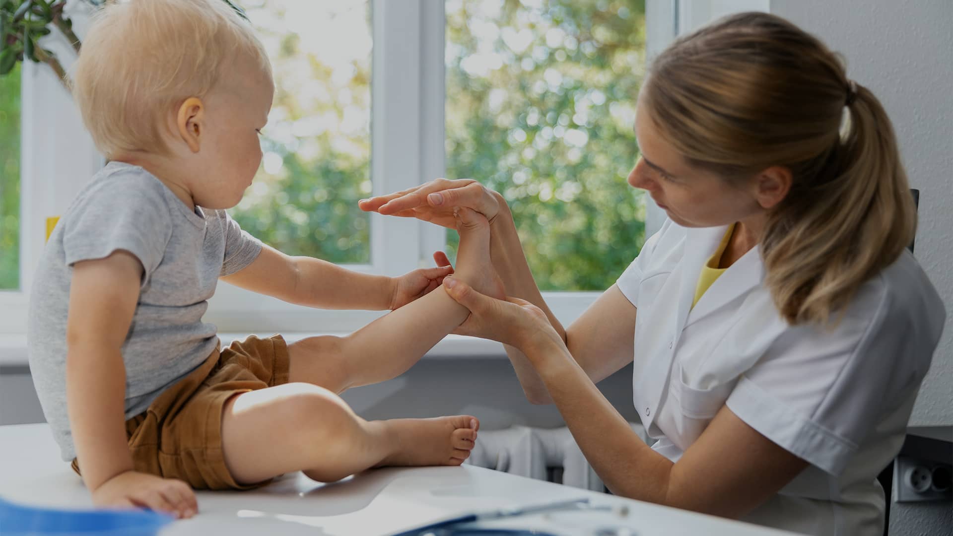 A specialist examining a young child's foot