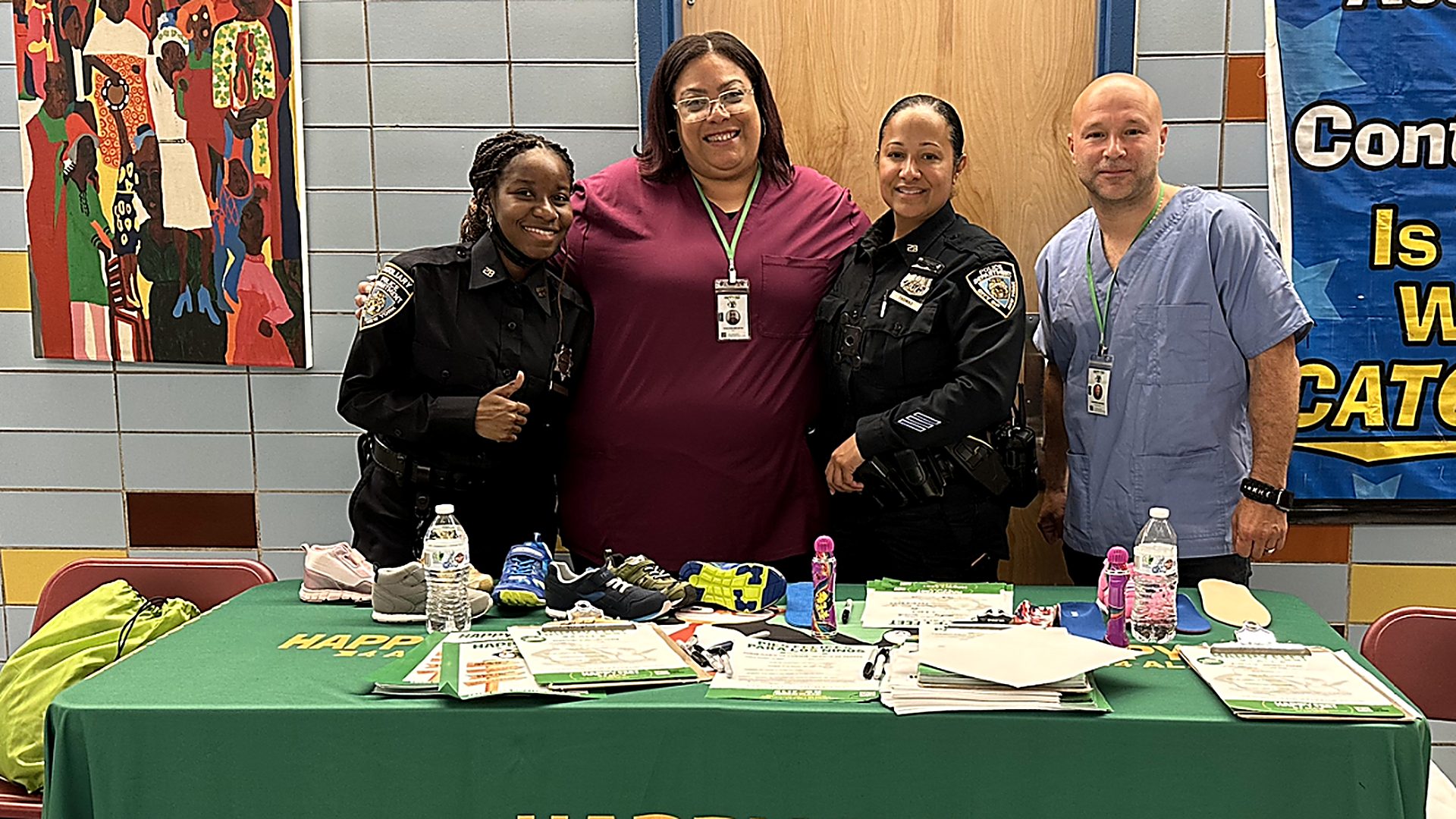 NYPD officers with the Happy Feet 4 All team at an on-site screening table in a school